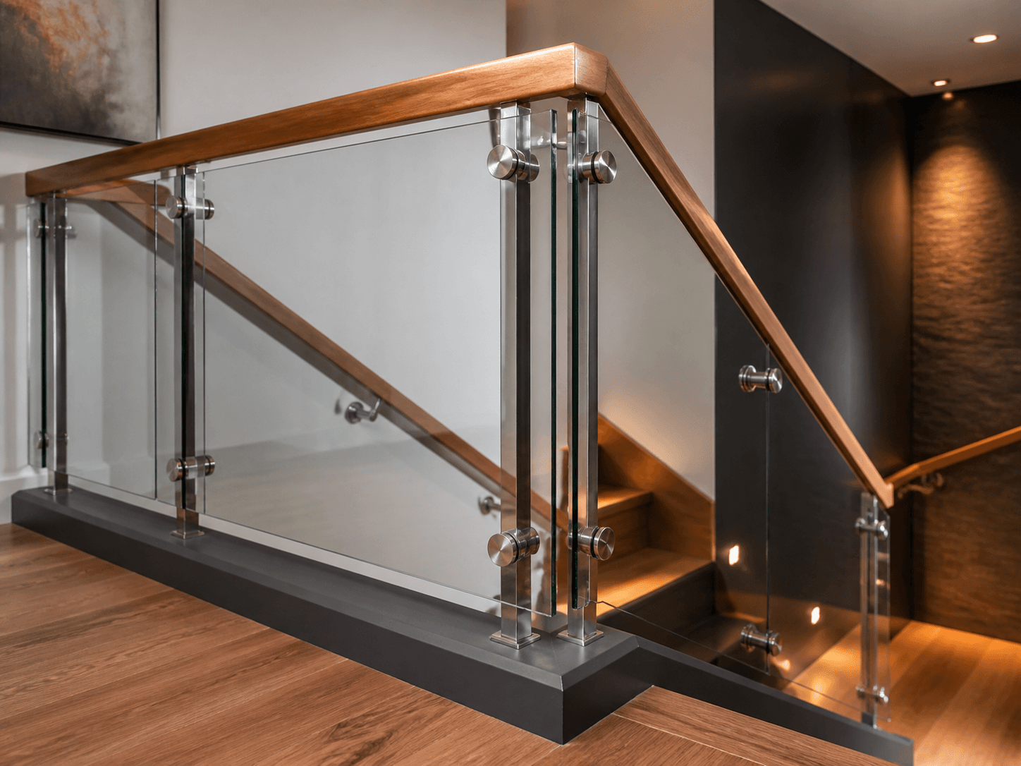 Cầu thang kính với tay vịn gỗ và trụ inox
